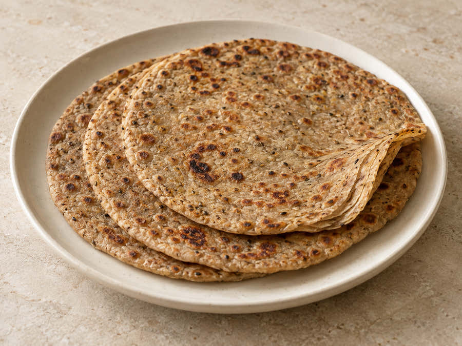 Wholegrain black wheat ajwain parathas on an ivory plate